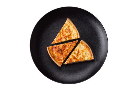 Beautiful delicious quiche pie with four types of cheese with spices and herbs on a dark concrete backgroundの写真素材
