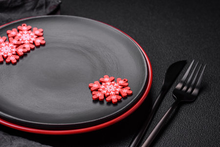 Empty ceramic black plate with christmas decoration elements on holiday textured concrete backgroundの写真素材