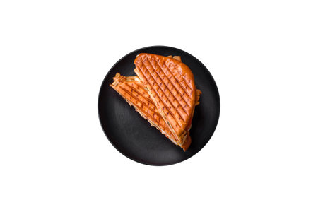 Delicious crispy sandwich with chicken breast, tomatoes, ketchup and spices on a dark concrete backgroundの写真素材