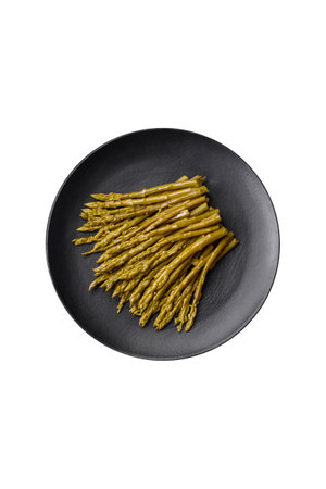 Sprigs of delicious canned asparagus on a black ceramic plate on a dark concrete backgroundの写真素材