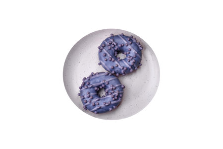 Delicious sweet donut of purple color in glaze and with lilac balls with chocolate filling on a dark concrete backgroundの写真素材