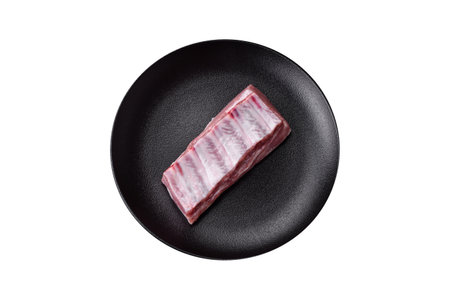 Raw pork ribs with salt, spices and herbs on textured concrete backgroundの写真素材