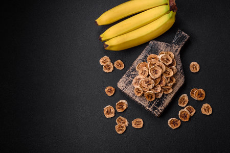 Round slices of sweet banana on a dark concrete background. Ingredients for making vegan sweetsの写真素材