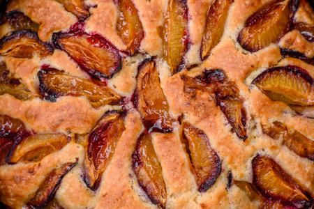 Delicious sweet aromatic homemade pie with ripe plums on a dark concrete backgroundの写真素材
