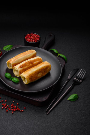Delicious fresh homemade fried pancakes with broccoli and meat or fish with salt and spices on a dark concrete backgroundの写真素材