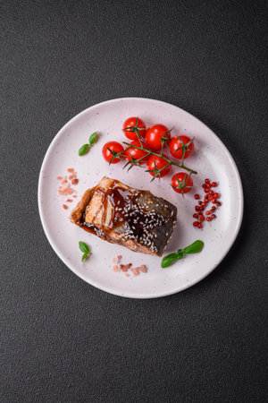 Delicious grilled salmon fillet with salt, spices, herbs and sauce on a dark concrete backgroundの写真素材