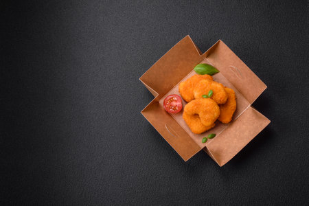 Delicious fresh crispy chicken nuggets on a dark concrete background. Unhealthy food, fast foodの写真素材