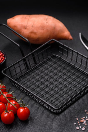 A black mesh or basket for deep-frying and cooking potatoes in boiling oil. Cooking fast foodの写真素材