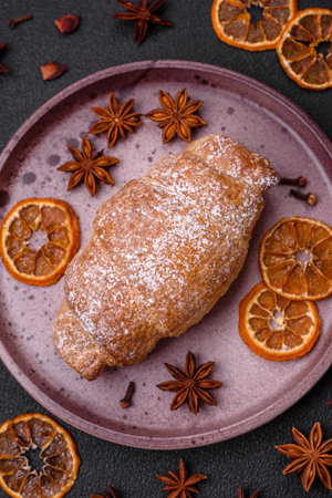 Delicious fresh sweet crispy croissants with chocolate cream on a ceramic plate on a dark concrete...