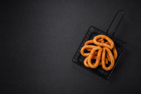 Delicious sweet churos with powdered sugar and cream inside on a dark concrete background. Fast food dishの写真素材