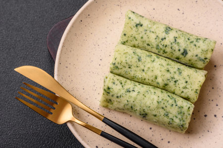Delicious fresh pancakes with spinach, cream cheese, salmon, salt and spices on a dark concrete...