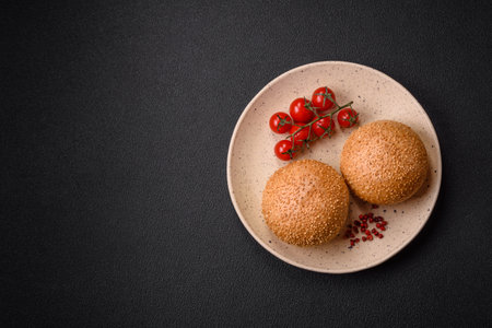 Delicious fresh crispy white round bread with seeds and grains on a dark concrete backgroundの写真素材