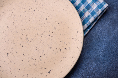 Round empty colored ceramic plate on concrete texture background. Preparing dishes and cutlery for dinnerの写真素材