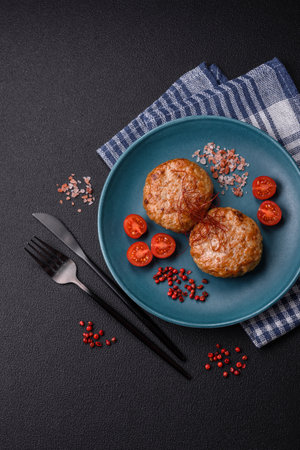 Delicious fresh fried minced fish cutlets with spices and herbs on a dark concrete backgroundの写真素材