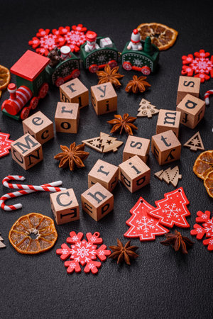 Beautiful Christmas composition with copy space with an inscription in wooden cubes on a black concrete backgroundの写真素材