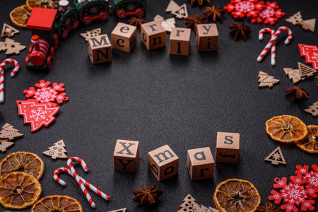 Beautiful Christmas composition with copy space with an inscription in wooden cubes on a black concrete backgroundの写真素材