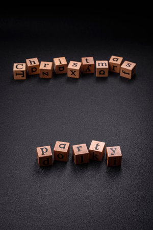 Christmas party inscription with wooden cubes on a dark concrete background. Postcard with copy space for your designの写真素材
