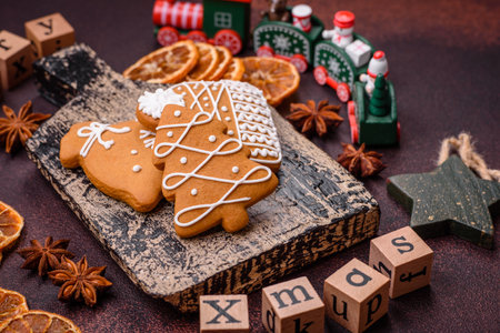 Beautiful delicious sweet winter Christmas gingerbread cookies on a bronze textured background. Preparing for a family holidayの写真素材