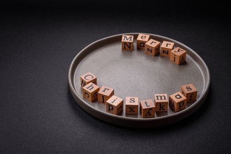 Beautiful Christmas composition with copy space with an inscription in wooden cubes on a black...