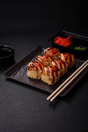 Delicious warm sushi roll with tuna, salmon, shrimp, cucumber and cream cheese on a dark concrete backgroundの写真素材