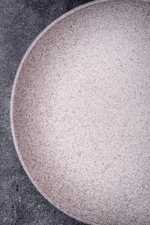 Empty round ceramic plate as an item of kitchen utensils on a textured concrete backgroundの写真素材