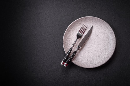 Bumpy empty ceramic plate on a textured concrete background. Kitchen utensil itemの写真素材