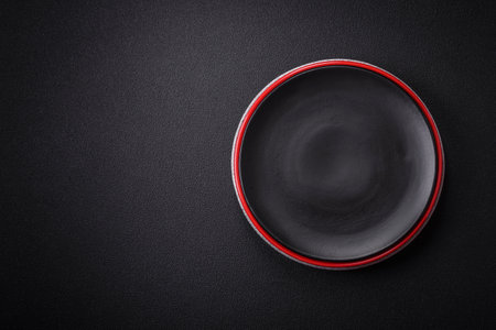 Bumpy empty ceramic plate on a textured concrete background. Kitchen utensil itemの写真素材