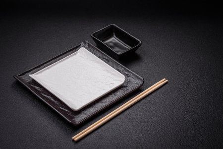 Square empty ceramic plate on textured concrete background. Kitchen utensil itemの写真素材