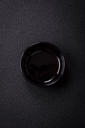 Beautiful empty black ceramic gravy boat on a textured concrete background. Kitchen utensil itemの写真素材