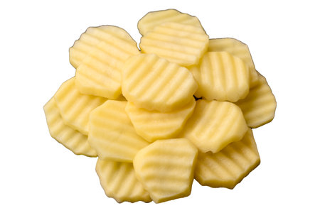 Raw fresh potatoes cut into slices on a black ceramic plate on a dark concrete backgroundの写真素材