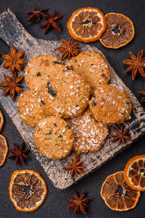 Delicious sweet round sponge cookies sprinkled with coconut flakes on a dark concrete backgroundの写真素材