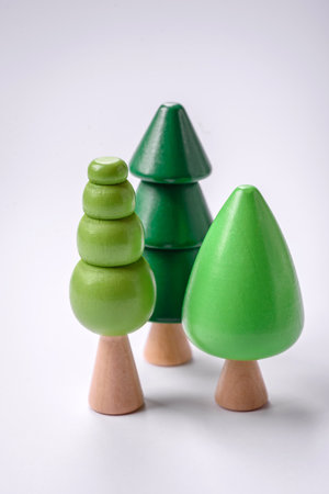 Wooden model of a tree with a green crown and trunk on a white background. Child growth with wooden...