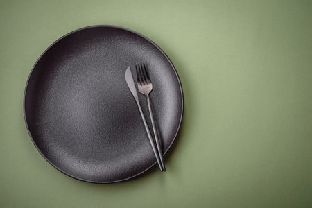 Empty round ceramic plate on a plain background, flatley with copy space. Kitchen utensils in home kitchenの写真素材