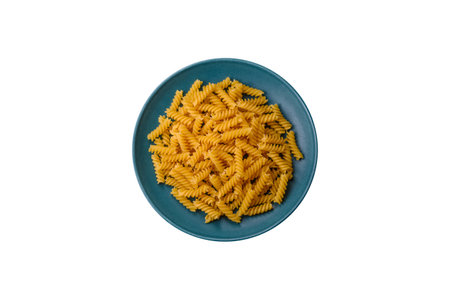 Raw fusilli pasta from whole grain wheat varieties on a dark textured background