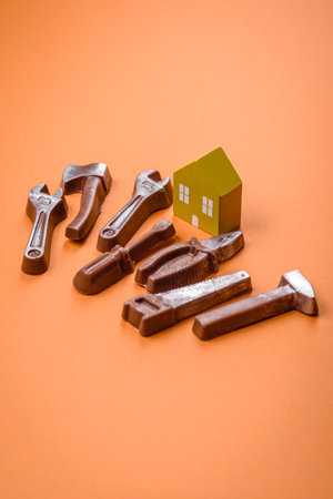 Repair or home improvement tools and a house model on a plain background. Background for your design