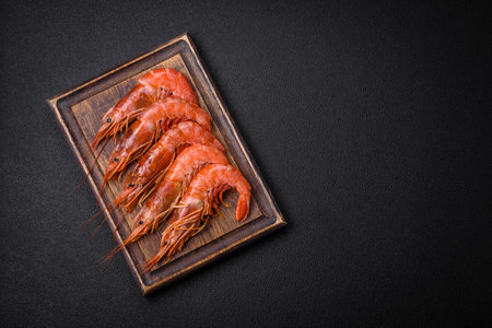 Tiger shrimp or langoustine boiled with spices and salt on a dark concrete backgroundの写真素材