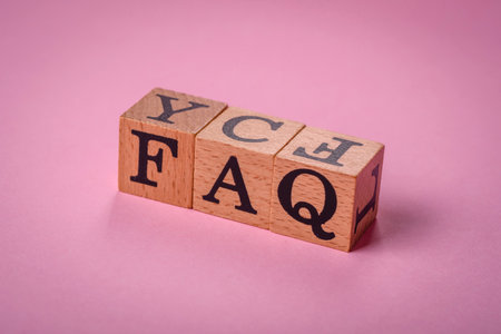The inscription FAQ made up of wooden cubes on a plain background. Can be used for your designの写真素材