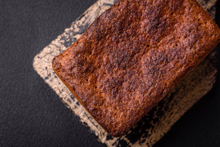 Delicious fresh crispy brown bread with seeds and grains on a dark concrete background