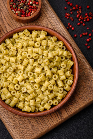 Delicious ditali pasta from durum wheat with salt and spices on a dark concrete backgroundの写真素材