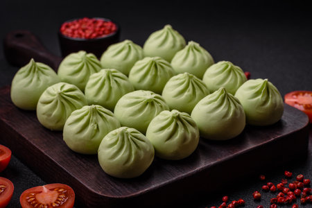 Raw khinkali or green dumplings with salt, spices and herbs on a dark concrete backgroundの写真素材