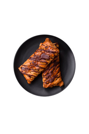 Delicious crispy sweet puff pastry with chocolate and salted caramel on a dark concrete background
