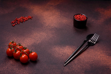 Empty concrete kitchen surface with salt, allspice and cherry tomatoes, copy space. Cooking at homeの写真素材