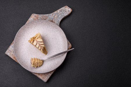 Piece of delicious sweet esterhazy cake with nuts and cream on a dark concrete backgroundの写真素材