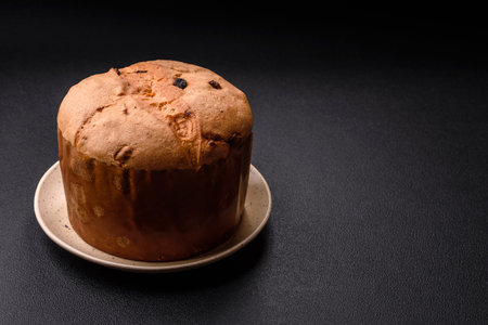 Delicious sweet holiday panettone cake with zest and raisins on a ceramic plate. Holiday table attributeの写真素材
