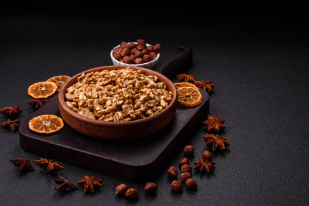 Delicious fresh peeled raw walnuts in a ceramic plate on a dark concrete backgroundの写真素材