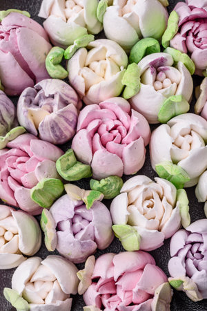 Beautiful tasty marshmallows in the form of tulip buds on a dark concrete backgroundの写真素材