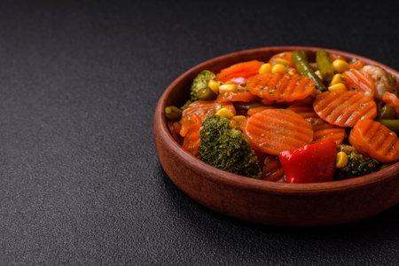 Delicious healthy vegetables steamed carrots, broccoli, asparagus beans and peppers on a dark concrete backgroundの写真素材