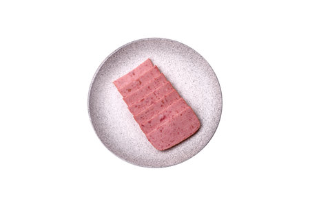 Delicious canned pink ham with salt, spices and herbs on a dark concrete background