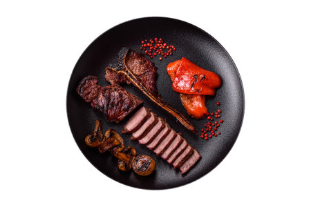 Delicious juicy beef tbone steak with salt, spices and herbs on a dark concrete backgroundの写真素材