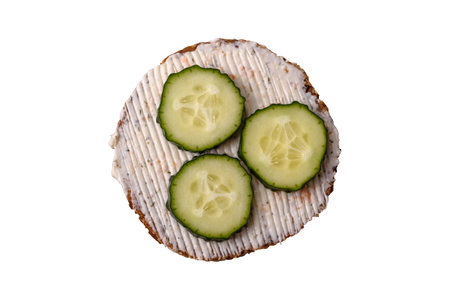 Delicious vegetarian sandwich with grilled toast, cream cheese, cucumbers and seeds and grains on a dark concrete backgroundの写真素材